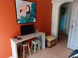 Habitación con escritorio y TV en la pared. en Quinta Pereiro Tropic Garden, Algarve, en Moncarapacho