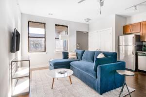 a living room with a blue couch and a table at CozySuites Music Row Bold 1BR w free parking in Nashville