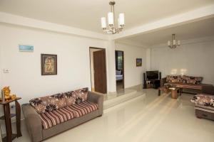 Sala de estar con 2 sofás y mesa en Ama Residency & Homestay Kandy, en Hindagala