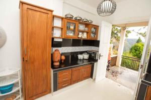 a kitchen with wooden cabinets and a stove at Ama Residency & Homestay Kandy in Hindagala