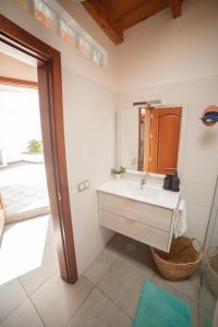 een badkamer met een wastafel en een spiegel bij Casa del Mercado in Haría