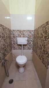 a bathroom with a white toilet in a room at ARJUN PAYING GUEST HOUSE in Ayodhya