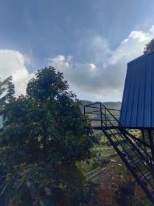 vistas a un árbol y a un edificio azul en PAPATHI KUDIL, en Kodaikanal