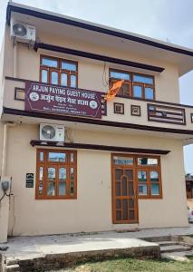 un edificio con un letrero que lee la casa de huéspedes en ARJUN PAYING GUEST HOUSE en Ayodhya
