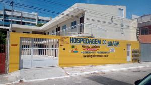 un edificio amarillo con un cartel en el costado en Cabo Frio - Braga - Kitnets - Aluguel Econômico, en Cabo Frío