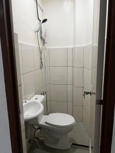 a bathroom with a toilet and a sink at Calo Apartel in Panabo