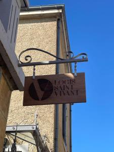 una señal colgando de un lado de un edificio en Logis Saint Vivant, en Volnay