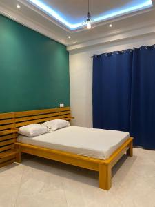 um quarto com uma cama com uma parede em tons de azul em Residence SIRTAK em Cotonou