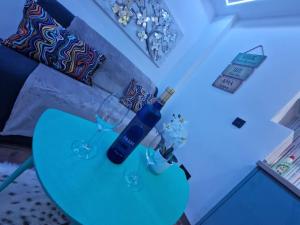 a blue table with a bottle and glasses on it at Sierra Love apartamento abierto in Prado del Rey