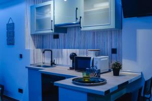 uma cozinha azul com um lavatório e um micro-ondas em sensual sierra love em Prado del Rey