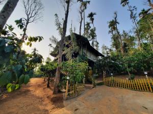 eine kleine Hütte mit einem Zaun davor in der Unterkunft The Mountain Tree home in Wayanad