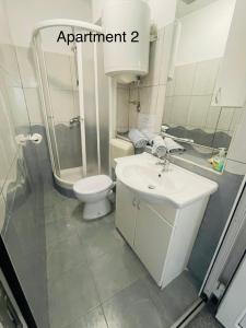 a bathroom with a white sink and a toilet at Lili apartman in Vodice +16 photos