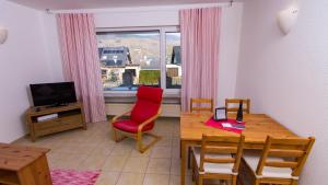 - un salon avec une table et une chaise rouge dans l'établissement Weingut Roth, à Kindel