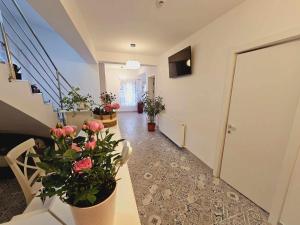un pasillo con una escalera con flores y plantas en Pensiune/Bistro ANNE MARIE, en Techirghiol