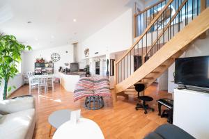 een woonkamer met een trap en een keuken bij Mialie Duplex familial classé 3 étoiles in Le Boulou