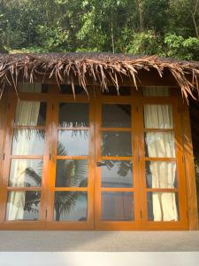 un edificio con techo de paja y ventanas en Tuburan Cove Beach Resort en Buruanga