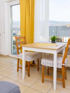 - une table et des chaises dans une chambre avec fenêtre dans l'établissement Weingut Roth, à Kindel