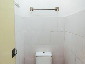bagno piastrellato bianco con servizi igienici di Eleven Guest House Syariah a Sukaraja