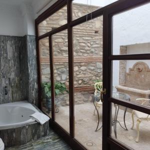 a bathroom with a tub and a window at Suite Comares in Granada