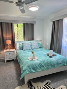 Un dormitorio con una cama con un edredón azul. en Kirwan RetreatTownsville, en Ross River