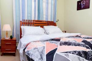 Tempat tidur dalam kamar di Family Friendly 2-BR Apartment Near Mlimani City