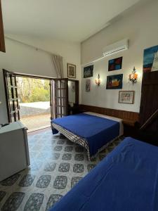 1 Schlafzimmer mit 2 Betten mit blauer Bettwäsche und einem Fenster in der Unterkunft FONDAZIONE VILLA POINT ONLUS in San Felice Circeo