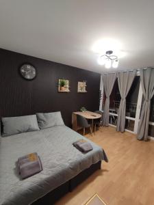 a bedroom with a bed and a table and a clock at Apartment Ferienunterkunft Strandnähe mit Pools in Sunny Beach