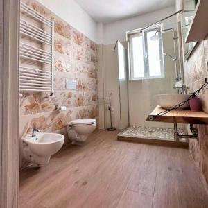 a bathroom with a sink and a toilet and a tub at Armonia Casa Vacanze Experience in Taranto
