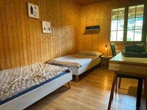 two beds in a room with wood paneled walls at Ferienwohnung im Chalet Bergruh - Hasliberg Reuti in Hasliberg