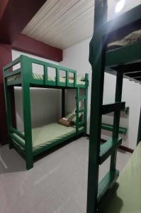 een groen stapelbed in een kamer met een ladder bij 2Ms in Baguio +2 foto's