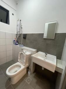 a bathroom with a toilet and a sink at Sandakan Blue Coastal escape 蓝海岩栖 in Sandakan