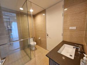 Un baño con ducha de cristal y lavabo. en Batu Ferringhi By The Sea 2BR Suite 6 Pax, en Batu Ferringhi 11 fotos más