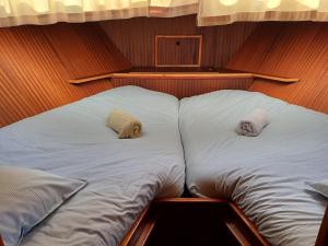 a large bed with two pillows on a boat at Motor Yacht Amstelle in Amsterdam