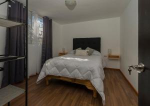1 dormitorio con 1 cama y suelo de madera en Charming 3-Bed House in Chihuahua en Chihuahua