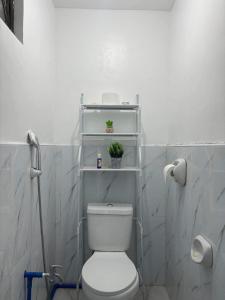 ein Badezimmer mit WC und eine Pflanze auf einem Regal in der Unterkunft Aurora's Place Private Pool 