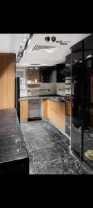 een grote keuken met zwart marmeren aanrechtbladen bij شقه فندقيه للايجار بكمبوند كريستال بلازا in Caïro