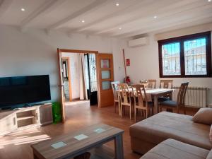 a living room with a television and a table and chairs at Villa Pablo, Despeñaperros in Santa Elena