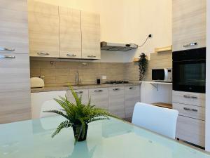 cocina con mesa de cristal y sillas blancas en Gallery Fiera Milano, en Cornaredo