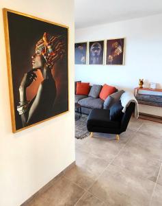 uma sala de estar com um sofá e uma pintura de uma mulher em דירת נופש נוף לכנרת em Migdal