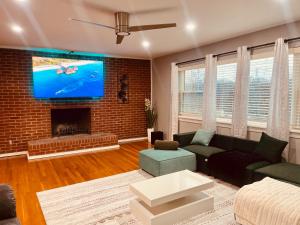 Cincinnati Cozy Entertainment home downtown في سينسيناتي: غرفة معيشة مع أريكة وتلفزيون