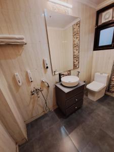uma casa de banho com um lavatório, um WC e um espelho. em Hotel Diamond Airport Near TERMINAL 3 em Nova Deli