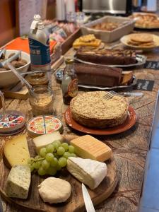 那慕爾的住宿－STUDIO VUE SUR MEUSE，餐桌上放着奶酪和葡萄,还有蛋糕
