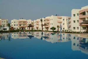 a large pool in front of some apartment buildings at Mohammedia Plage et piscines in Mohammedia