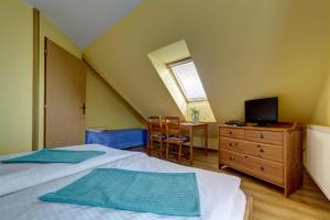 a bedroom with two beds and a tv and a dresser at Apartmany Na Skle Malovane in Liptovská Kokava