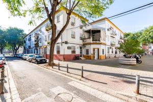 un edificio en una calle con coches aparcados en la calle en Apartamento Triana Los Remedios en Sevilla