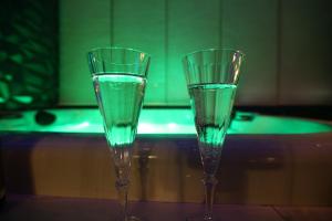 two glasses sitting on top of a table with a bath tub at Flower Suite and Spa in La Seyne-sur-Mer