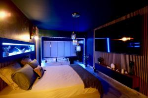 una camera da letto con un grande letto con luci blu di Flower Suite and Spa a La Seyne-sur-Mer