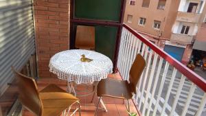 - une table et des chaises sur un balcon avec un oiseau dans l'établissement Piso para compartir, à Santa Coloma de Gramanet