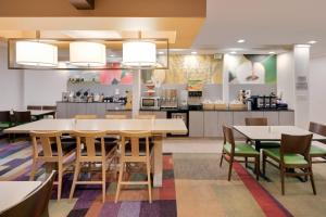 a dining room with tables and chairs and a kitchen at Fairfield Inn & Suites Austin University Area in Austin