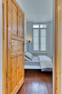 um quarto com uma cama e uma grande porta de madeira em Thomas, F2 moderne au coeur de la Bouille em La Bouille